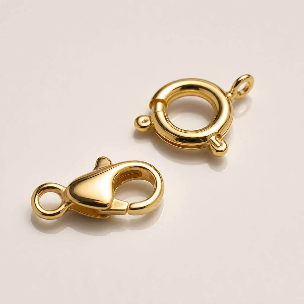 organized factory sample tray showing 316L stainless steel clasps, jump rings, and charm pendants